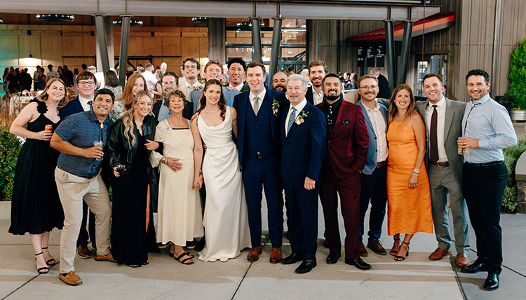 A group of people smiling at a wedding.