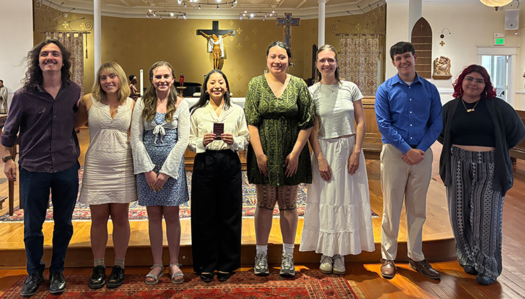 A group of students stand in a line in front of an altar in the school chapel.
