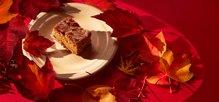 A photo of an apple blondie surrounded by leaves.