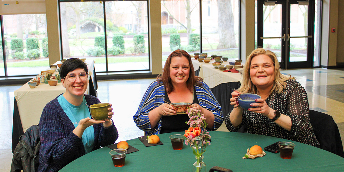 People eating soup at a table.