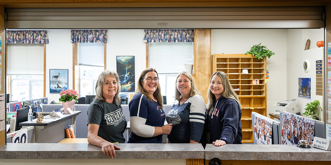 Four women smiling in a row.