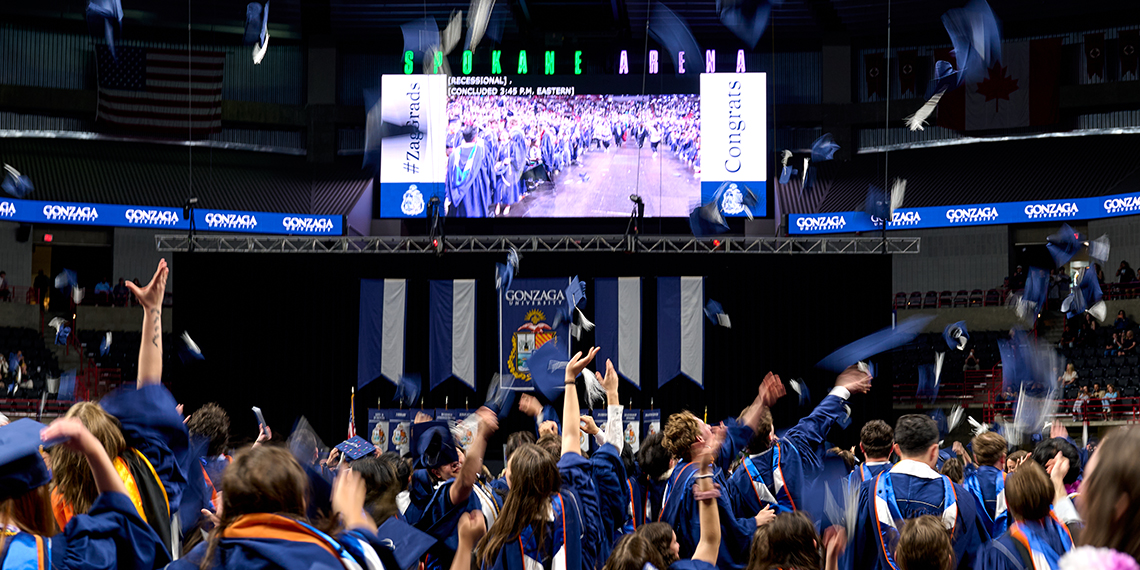 Graduates throwing grad caps in the air.