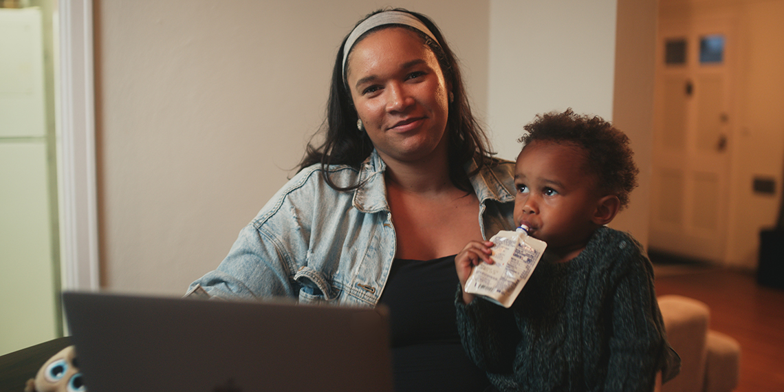 Jordy Jones poses with her laptop and her son on her lap.