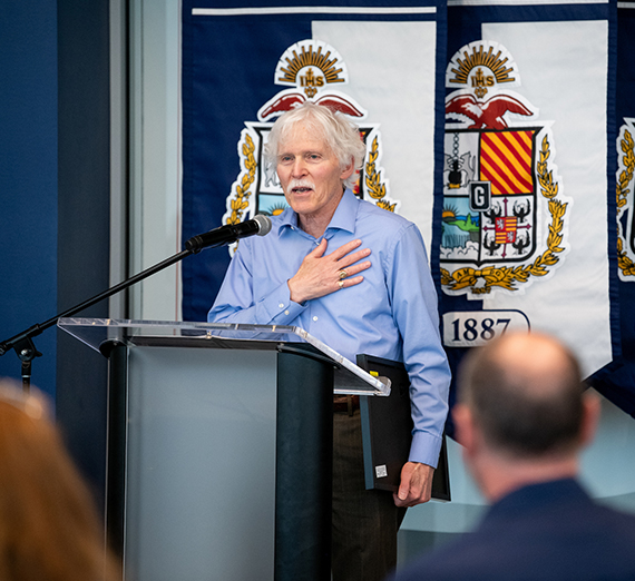 man with white hair at podium