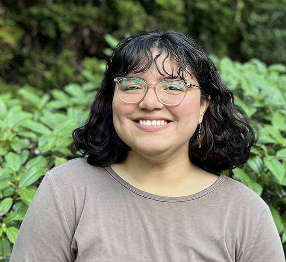 A woman with dark hair and glasses smiles