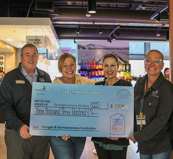 Four people holding trash bags.