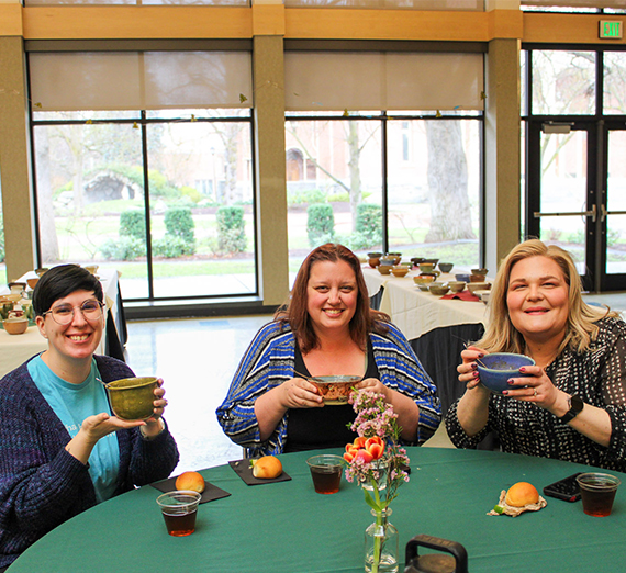 People eating soup at a table.