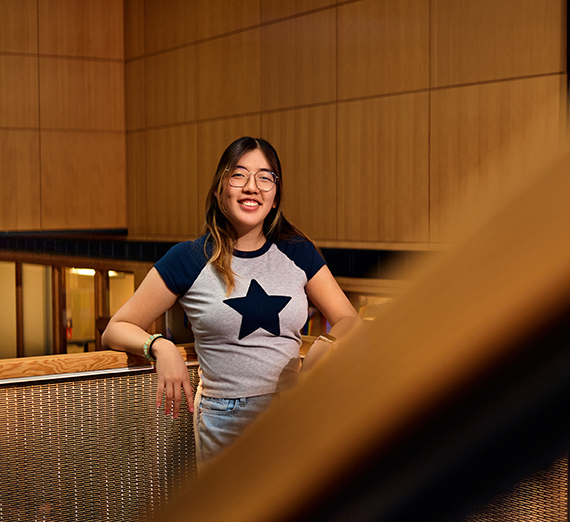 Woman in a t-shirt with a star on it leans against a railing