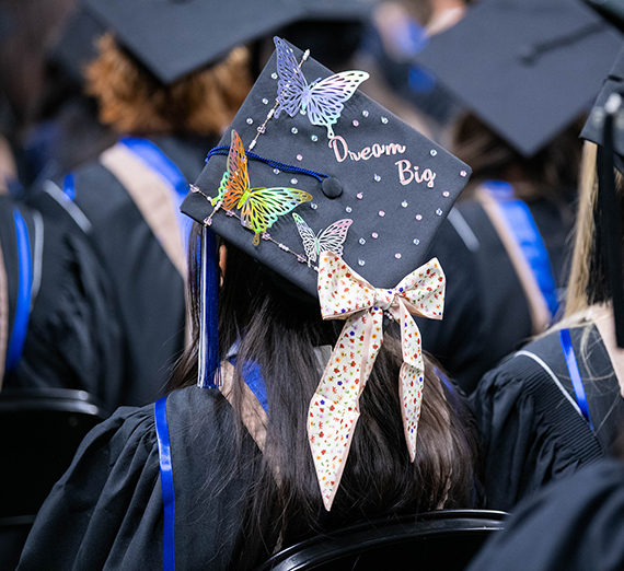 A graduation cap with butterflies attached and the words Dream Big