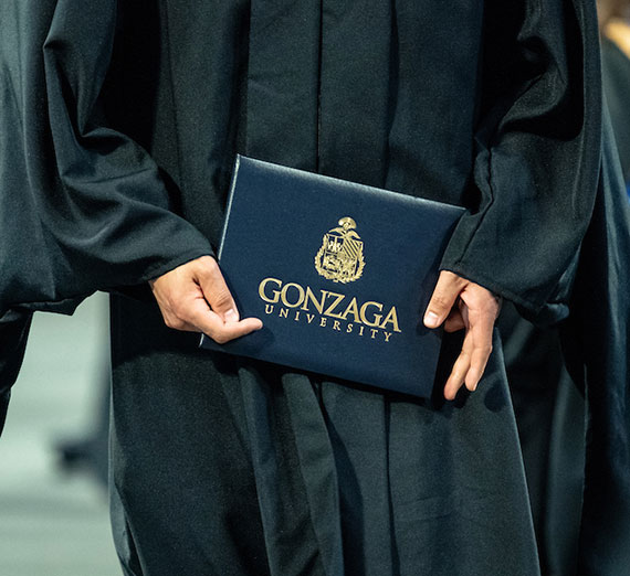 Student holding Gonzaga Grad diploma.