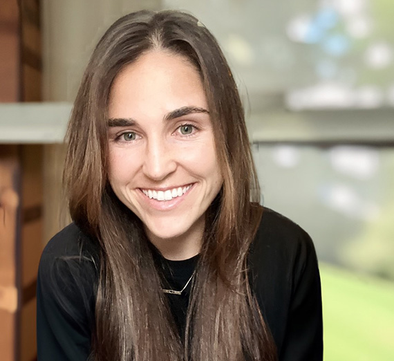 Master of Accountancy alumna, Lucy Ferrari wearing a blackshirt with brown and green blurry background