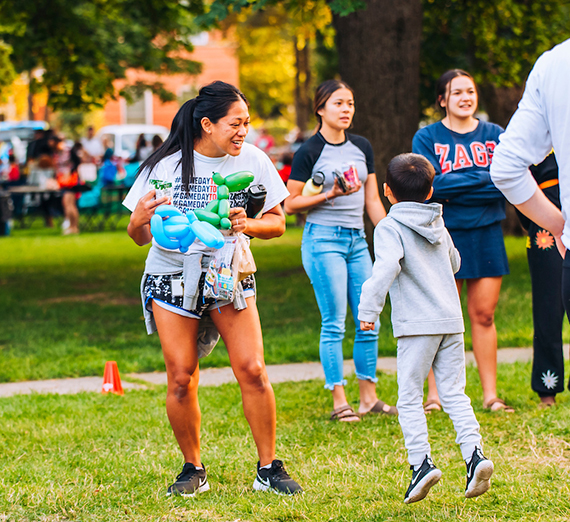 Mother and son jump excitedly while playing a lawn game at the Logan Block Party