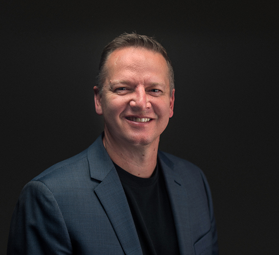 A man in blazer smiles at camera