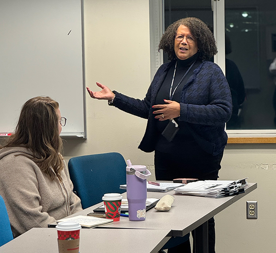 A woman stands at a white board in a classroom