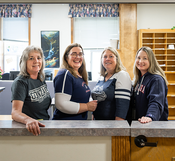 Four women wearing Ƶ gear stand in a row through a window.