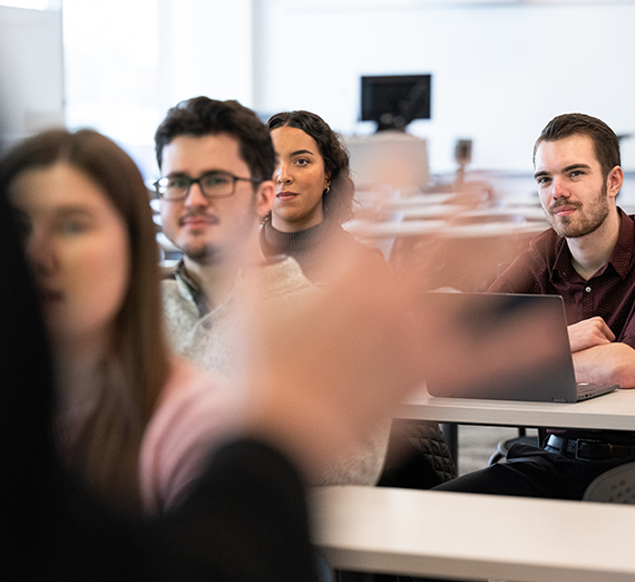 Students in a classroom listening to a professor. 