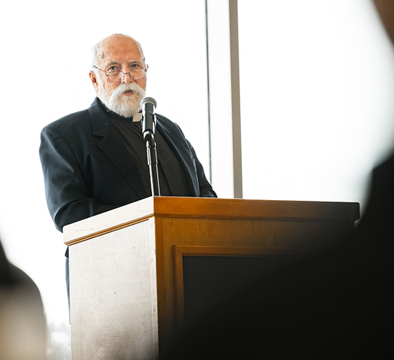 Father Neeley stands at a podium.