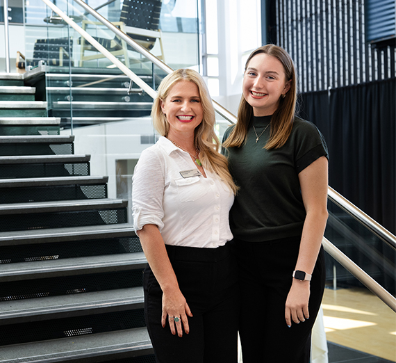 two women on stairs smiling