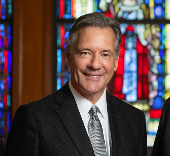 Mike Reilly smiling in front of Chapel windows.