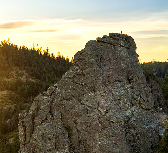 A climber from Gonzaga's Immersive Outdoor Learning program stand atop the Rocks of Sharon.