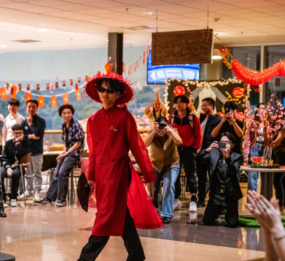 Tet lunar new year at the COG, student walking in traditional red dress.