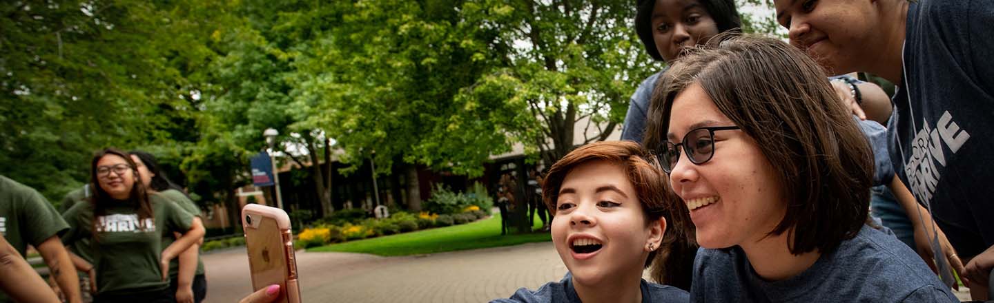 Students of color pose for a selfie camera shot.