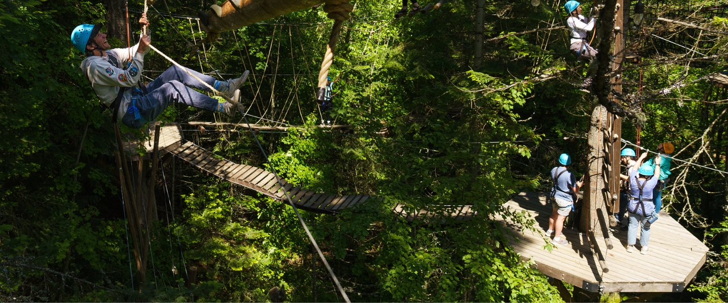 Explorers climbing through a high ropes course