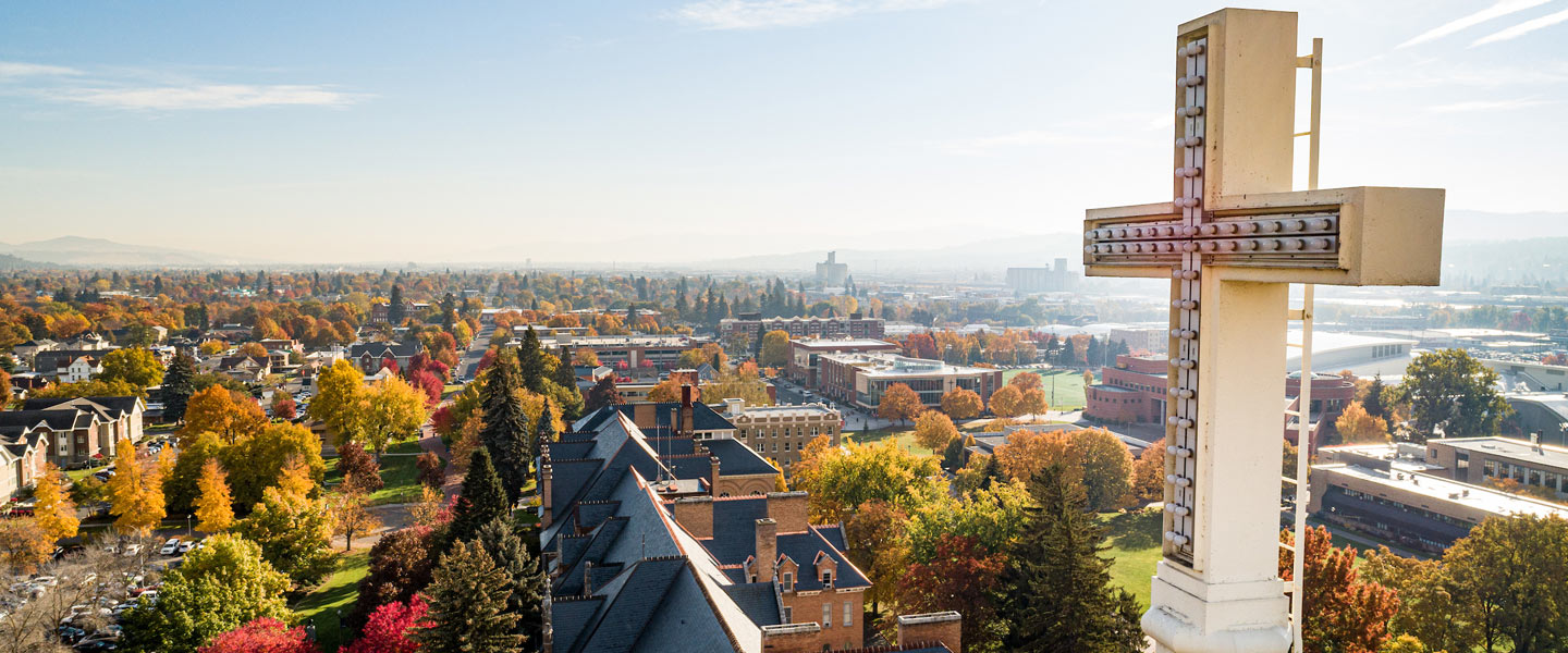 Drone photo overlooking Gonzaga University's campus during the fall, with the top of a spire from St. Aloysius church in the foreground