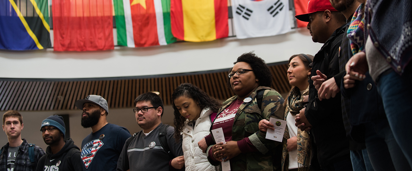 Students stand side by side with linked arms to celebrate the International Day of Tolerance.