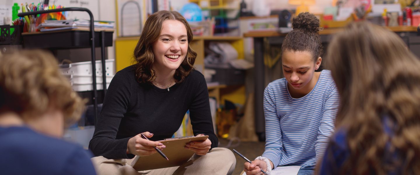 Student teacher sits in group of students