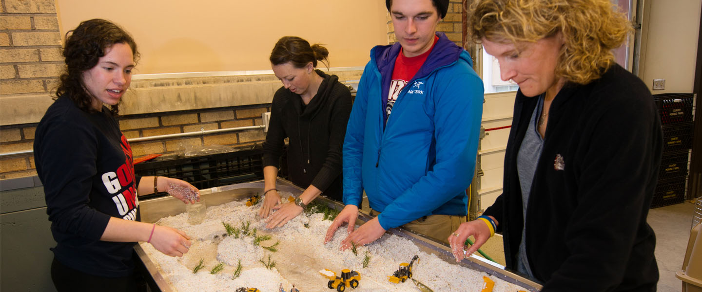 Professor and students work with river simulation 