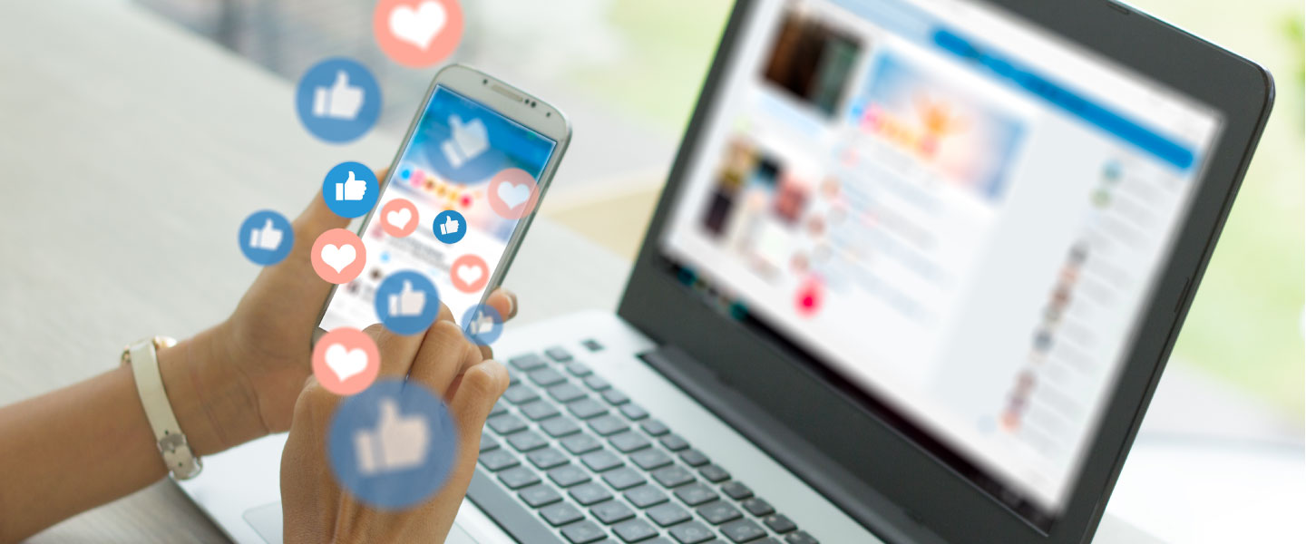 stock photo of a laptop and mobile device screens displaying social media feeds 