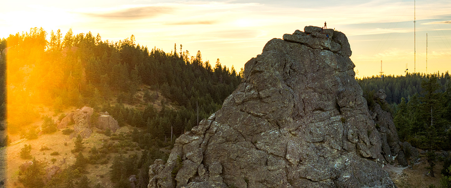 A climber with Gonzaga's Outdoor Learning Program stands atop the Rocks of Sharon.